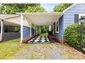 Attached carport with checkered flooring and blue accents, providing covered parking at 430 Sells Rd, Salisbury, NC 28144