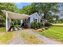 Charming blue home with attached carport, lush landscaping, and a gravel driveway at 430 Sells Rd, Salisbury, NC 28144