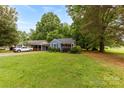 Charming blue home with lush green lawn, mature trees, and well manicured front yard at 430 Sells Rd, Salisbury, NC 28144