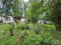 Exterior of a house with a garage surrounded by lush green trees at 455 Running Brook Rd, Midland, NC 28107