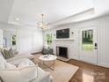 Bright living room with a cozy fireplace, modern lighting, and a comfortable sectional sofa at 4921 Doris Ave, Charlotte, NC 28205