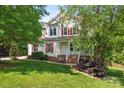 Charming two-story home featuring a covered front porch with classic white columns and well-manicured lawn at 5022 Saybrook Dr, Harrisburg, NC 28075