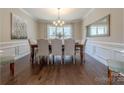 Formal dining room featuring wainscoting, hardwood floors, a chandelier, and ample natural light at 5128 Oakhaven Ln, Fort Mill, SC 29708