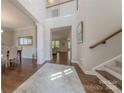 Grand foyer with high ceilings, hardwood floors, elegant staircase, and views into the dining and living spaces at 5128 Oakhaven Ln, Fort Mill, SC 29708