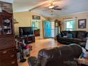 Inviting living room with hardwood floors, beamed ceiling, brick fireplace, and comfortable leather furniture at 5908 Tanson Trl, Marshville, NC 28103