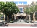 Exterior view of a brick building with trees, outdoor seating, and a covered entrance for the condominiums at 721 Governor Morrison St # 520, Charlotte, NC 28211
