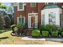 Inviting front entrance with a red door, brick steps, and lush landscaping adds charm at 8211 Abbottsgate Ln, Charlotte, NC 28269