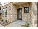 Charming brick entryway with a modern black door, stone landscaping and well-maintained shrubbery at 842 Van Every St, Charlotte, NC 28205