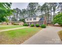 Spacious two-story house with a lush lawn, mature trees, and a long driveway at 8525 Castlekeep Rd # 26, Charlotte, NC 28226