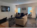 A living room with neutral tones, layered textiles, a television, and two windows at 9340 Grand Valley Dr, Charlotte, NC 28213