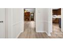 Inviting hallway with hardwood floors, leading to a living room with a brick fireplace at 9640 Heartwood Ln, Mint Hill, NC 28227