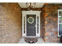 Charming front door with brick and stone accents, elegant wreath, and stylish exterior lighting at 10205 Alouette Dr, Waxhaw, NC 28173