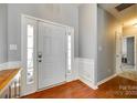 Bright foyer featuring wood flooring, light gray walls, and a white front door with glass accents at 1301 Cool Mist Ct, Indian Land, SC 29707