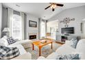 Bright living room featuring vaulted ceilings, fireplace, white couches, and hardwood floors at 1301 Cool Mist Ct, Indian Land, SC 29707