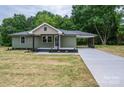 Charming single-story home with olive green siding, covered carport, and newly seeded front yard at 1428 E Main St, Cherryville, NC 28021