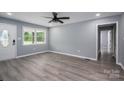 Bright living room featuring new gray wood-look flooring, gray paint, and a ceiling fan at 1428 E Main St, Cherryville, NC 28021