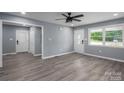 Bright living room featuring new gray wood-look flooring, gray paint, a window, and a ceiling fan at 1428 E Main St, Cherryville, NC 28021
