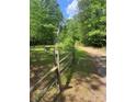 View of the property line with a wooden fence, greenery, and a glimpse of the natural surroundings at 1502 Shelby Hwy, Cherryville, NC 28021