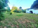 Large grassy backyard featuring mature trees, ideal for outdoor activities at 16603 Nc Hwy 73 Hwy, Albemarle, NC 28001