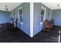 Relax on this covered front porch with rocking chairs and bench, perfect for enjoying the outdoors at 174 Perrin Dr, Mooresville, NC 28117