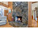 Living room with a stone fireplace, wood floors, and wood paneling at 192 Diana Dr, Mount Gilead, NC 27306