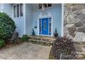 Inviting blue front door with decorative trim, stone steps, and manicured shrubs at 192 Diana Dr, Mount Gilead, NC 27306