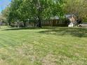 Large yard with mature trees surrounding a brick home with ample windows and attached garage at 205 Rudolph Rd, Salisbury, NC 28146