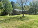 Expansive lawn and mature trees surround this brick home with bright, white-trimmed windows at 205 Rudolph Rd, Salisbury, NC 28146