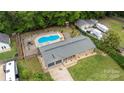 Aerial view of property with a pool, large backyard, detached garage and mature trees at 213 Lakeview Dr, Harrisburg, NC 28075