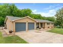 Brick ranch-style home with two-car garage and well-manicured landscaping on a sunny day at 213 Lakeview Dr, Harrisburg, NC 28075