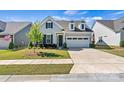 Charming home with a two-car garage, neat landscaping and an American flag displayed in the front yard at 213 Warbler Dr, Wesley Chapel, NC 28110