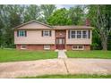 Attractive split-level home with a brick and tan facade, complemented by a green lawn at 2474 Cedar Valley Dr, Conover, NC 28613