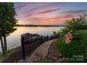 Picturesque stone walkway leading to a waterfront area, framed by lush landscaping and serene water views at 249 Landing Trl, Mount Gilead, NC 27306