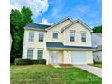 Inviting yellow two-story home features well-manicured lawn and an attached garage at 3032 Mallard Forest Dr, Charlotte, NC 28269
