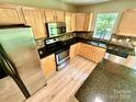 Updated kitchen featuring stainless steel appliances, wooden cabinets, and granite countertops at 3032 Mallard Forest Dr, Charlotte, NC 28269