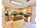 Well-lit kitchen featuring stainless steel appliances, wooden cabinets, and granite countertops at 3032 Mallard Forest Dr, Charlotte, NC 28269