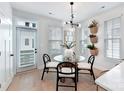 Bright dining area with a glass table, modern light fixture, and views of plants at 316 S Turner Ave # 11, Charlotte, NC 28208