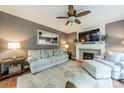 Inviting living room featuring a fireplace, comfortable seating, and a ceiling fan at 4201 Beauvista Dr, Charlotte, NC 28269