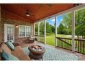 Cozy outdoor seating area on covered porch featuring comfortable seating, ceiling fans, and a view of the backyard at 422 Deer Brush Ln, Waxhaw, NC 28173