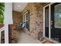 Inviting brick front porch with seating area next to the decorative front door at 422 Deer Brush Ln, Waxhaw, NC 28173