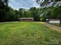 Single-story brick home with large yard and a detached shed on a quiet street at 5068 King Wilkinson Rd, Denver, NC 28037