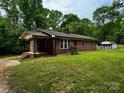 Quaint brick home with a covered front porch, small brick steps and landscaped yard at 5068 King Wilkinson Rd, Denver, NC 28037