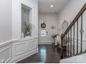 Elegant entryway featuring dark wood floors, decorative wall trim, staircase, and stylish accents at 5130 Mount Clare Ln, Charlotte, NC 28210