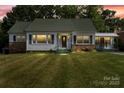 Charming home with a well-manicured lawn and welcoming curb appeal at dusk at 514 W Sumter St, Shelby, NC 28150