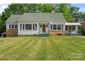 Charming home with a well-manicured lawn, green shutters, and stone accents at 514 W Sumter St, Shelby, NC 28150