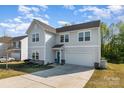 Beautiful home featuring neutral siding, a two-car garage, and a well-manicured lawn on a sunny day at 518 Dutch White Dr, Clover, SC 29710