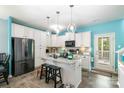 Modern kitchen boasts white cabinets, granite countertops, a kitchen island, and stainless steel appliances at 518 Dutch White Dr, Clover, SC 29710