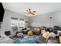 Comfortable living room featuring a gray sectional sofa, colorful rug, and a ceiling fan at 518 Dutch White Dr, Clover, SC 29710