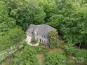 Stunning aerial view of a brick home nestled among lush green trees in a serene neighborhood at 5617 Sugarcane Ct, Mint Hill, NC 28227