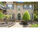 Welcoming front entrance featuring a black door with a wreath, surrounded by lush landscaping at 5617 Sugarcane Ct, Mint Hill, NC 28227